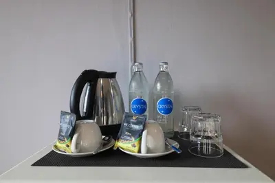 a tea kettle and two bottles of water on a counter at We Resident in Ban Bang Toei (1)