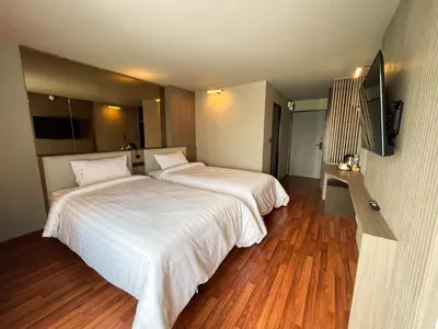 a hotel room with two beds and a flat screen tv at We Hotel in Ban Bang Toei (1)