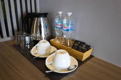 a table with two cups and two bottles of water at We Hotel in Ban Bang Toei (1)