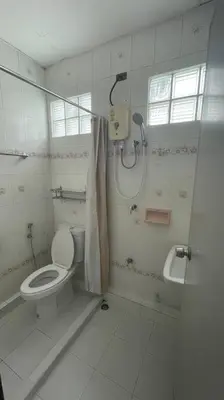 a white bathroom with a shower and a toilet at Manoo House E in Pratunam