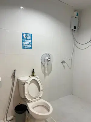 a bathroom with a toilet with a phone on the wall at Lemon Tree Hostel Khaosan in Bangkok