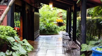 a patio with a bench and plants on a building at Vm1 Hostel in Bangkok