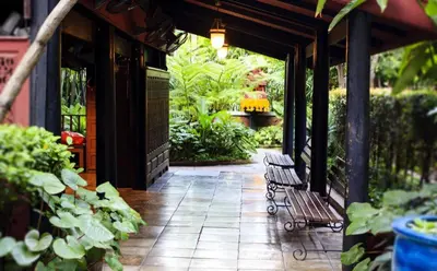 a patio with two benches on a building with plants at Vm1 Hostel in Bangkok