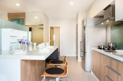 a kitchen with two stools and a counter in a room at Central 2BR 3 min walk from BTS Ploen Chit in Makkasan