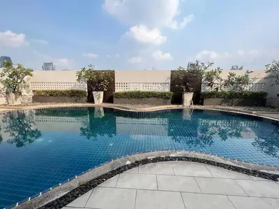 a large swimming pool with blue water at Central 2BR 3 min walk from BTS Ploen Chit in Makkasan