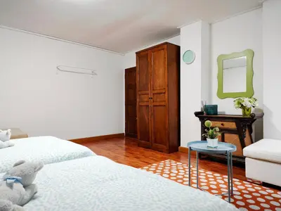 a bedroom with two beds and a table and a mirror at Maya Suite in Pratunam