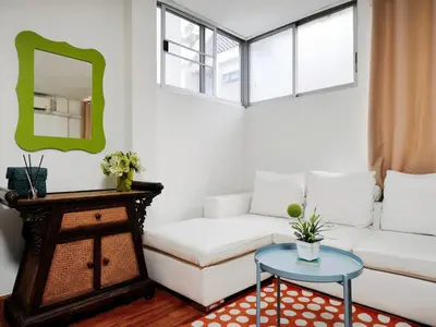 a living room with a white couch and a table at Maya Suite in Pratunam