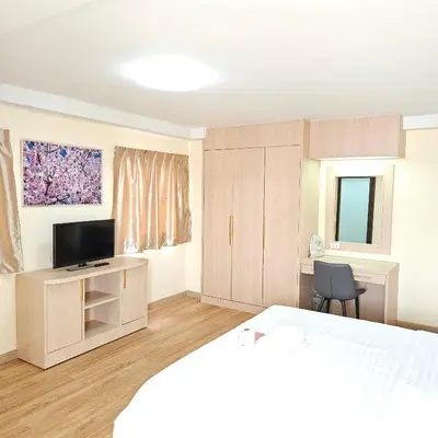 a bedroom with a bed and a desk with a television at Omni Suites 1Bed #702A in Bangkok