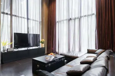 a living room with a couch and a television at Luxury Pool Villa with Jacuzzi & Lift by Thonglor in Bangkok
