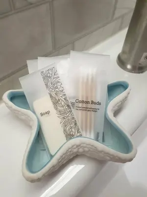 a pair of scissors sitting on a bathroom counter with coupons at Blue Da Bed บลูด้าเบด in Ban Khlong Khwang Klang