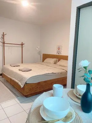 a bedroom with a bed and a table with plates at Jo Hometel in Lak Si