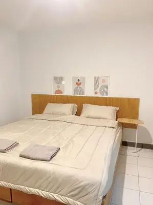 a large bed with two towels on top of it at Jo Hometel in Lak Si