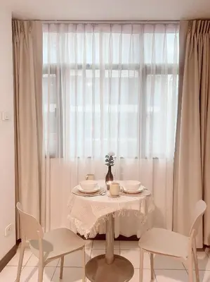 a table and chairs with a table and a window at Jo Hometel in Lak Si