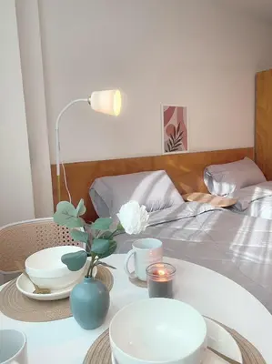 a table with plates and a lamp and a bed at Jo Hometel in Lak Si