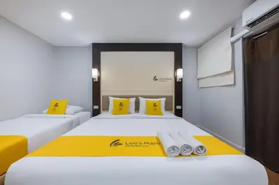 two beds in a room with yellow and white at Lee's Mark in Samutprakarn