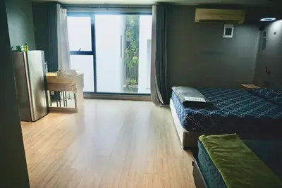 a hotel room with two beds and a large window at Triple room at Hash Apartment Silom Soi 3 in Bangkok
