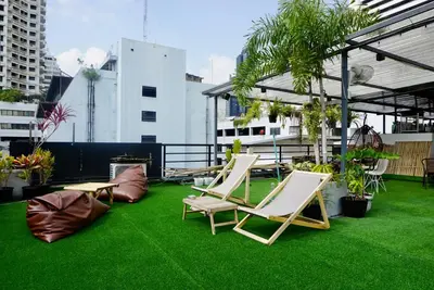 a patio with chairs and grass on a roof at Triple room at Hash Apartment Silom Soi 3 in Bangkok