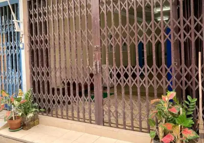 a gate in a building with plants and flowers at DaHouse next to MRT Itsaraphap exit1 in Bangkok Yai