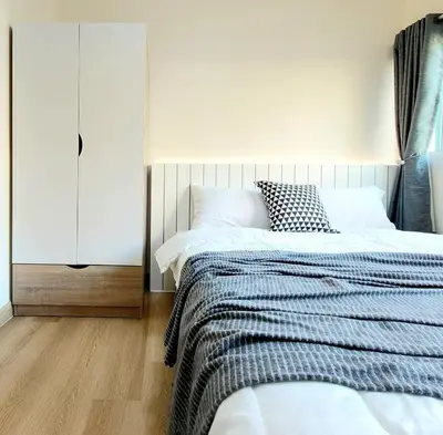 a bedroom with a bed and a white cabinet at Joyful room in Ban Song Hong