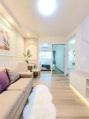 a living room with a couch and a dining room at Joyful room in Ban Song Hong