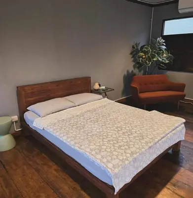 a bedroom with a bed and a couch and a chair at เฉื่อย โฮมสเตย์ in Nonthaburi