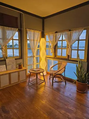 a room with two chairs and a table and windows at เฉื่อย โฮมสเตย์ in Nonthaburi