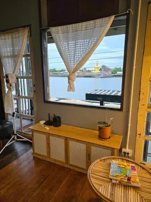 a room with a large window with a view of the water at เฉื่อย โฮมสเตย์ in Nonthaburi