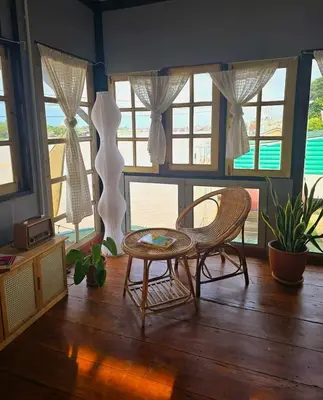 a room with a table and chairs and windows at เฉื่อย โฮมสเตย์ in Nonthaburi