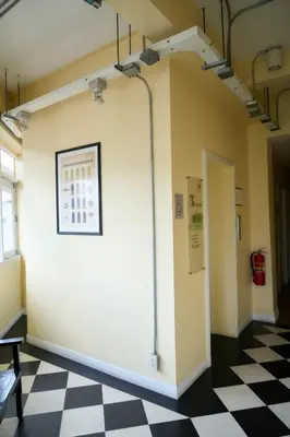 a room with a white wall and a checkered floor at Lamoon Vivit in Bangkok