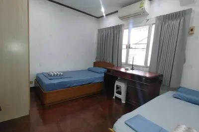 a bedroom with two beds and a desk and a window at \u7e41\u534e\u4e0e\u5e7d\u9759\u7684\u8054\u6392\u522b\u5885 \u8fd1\u5e15\u84dd9,\u62c9\u731c\u8fbe\u5730\u94c1\u7ad9,\u8ba25\u665a\u514d\u8d39\u63a5\u673a\u4e00\u8d9f in Bangkok