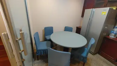 a kitchen with a table and chairs and a refrigerator at \u7e41\u534e\u4e0e\u5e7d\u9759\u7684\u8054\u6392\u522b\u5885 \u8fd1\u5e15\u84dd9,\u62c9\u731c\u8fbe\u5730\u94c1\u7ad9,\u8ba25\u665a\u514d\u8d39\u63a5\u673a\u4e00\u8d9f in Bangkok