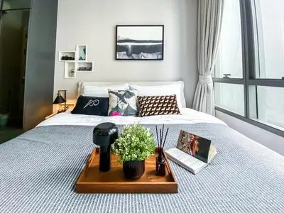 a bedroom with a bed with a tray with flowers on it at Magnificent Apt 1BR - Ultra Fast WiFi - Ekkamai in Bangkok