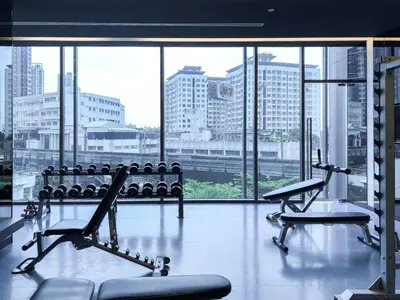 a gym with two benches and a large window at Magnificent Apt 1BR - Ultra Fast WiFi - Ekkamai in Bangkok