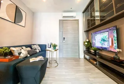 a living room with a blue couch and a tv at Magnificent Apt 1BR - Ultra Fast WiFi - Ekkamai in Bangkok