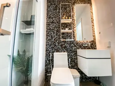 a bathroom with a toilet and a mirror at Magnificent Apt 1BR - Ultra Fast WiFi - Ekkamai in Bangkok