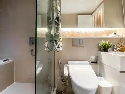 a bathroom with a toilet and a glass shower at Urban High-Rise - Ultra Fast WiFi - BTS Phrom Phong in Bangkok
