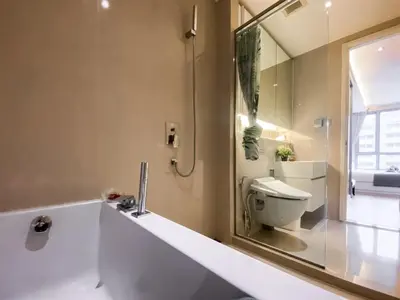 a bathroom with a sink and a toilet and a mirror at Urban High-Rise - Ultra Fast WiFi - BTS Phrom Phong in Bangkok