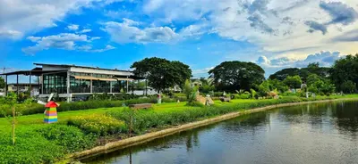 a building next to a river in a park at Tiny Island Lake Lodge in Bangkok