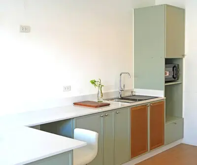 a kitchen with green cabinets and a sink at 499 House Villa in Bangkok