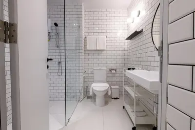 a white bathroom with a toilet and a sink at Mowa Bangkok in Bangkok
