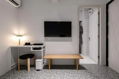 a room with a desk and a tv on a wall at Mowa Bangkok in Bangkok