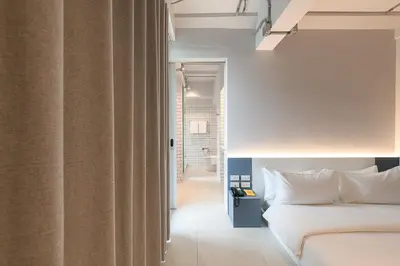 a bedroom with a white bed and a window at Mowa Bangkok in Bangkok