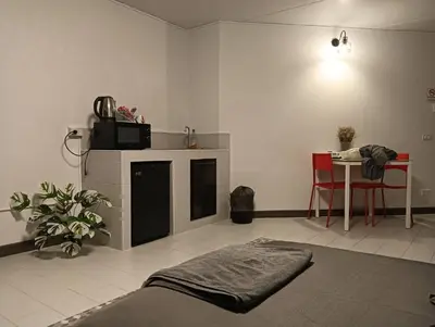 a living room with a table and a bed and a table and chairs at Popular Muang Thong Thani Condo, Building T9, Floor 4, Room 36 in Thung Si Kan