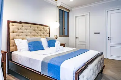 a bedroom with a large bed with blue pillows at Sukhumvit-Thonglor Luxury Pool Club Villa 5 Mins to BTS \u7d20\u5764\u9038-\u901a\u7f85 \u8c6a\u83ef\u6703\u6240\u6cf3\u6c60\u5225\u5885 5\u5206\u9418\u5230\u9054\u5730\u9435 in Bangkok