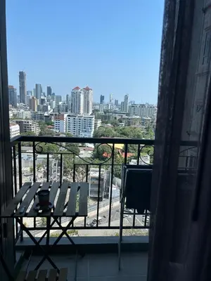 a balcony with a table and a view of a city at 1BR at Thonglor BTS InfinityPool overlooking city in Bangkok