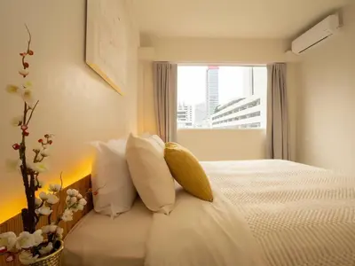 a bedroom with a bed with white pillows and a window at Cozy 2-bedroom apartment in Silom city center - 6A in Bang Rak