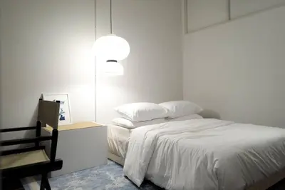 a bedroom with a bed and a table and a lamp at Nap by Snooze in Bangkok