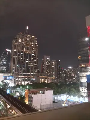 a city skyline at night with tall buildings at ZAYN Phrom Phong Hotel in Bangkok