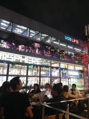a group of people sitting at tables in front of a building at ZAYN Phrom Phong Hotel in Bangkok