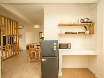 a small kitchen with a refrigerator and a table at 2 Bedroom apartment at Silom with city center view - 5A in Bangkok